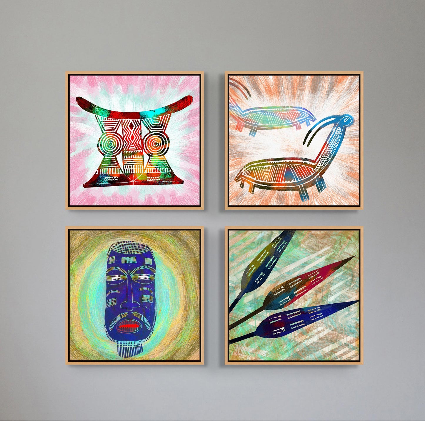 On a gray wall, four abstract artworks, including Goats - Contemporary African Design Canvas Art Print, highlight the vibrancy of African art with geometric patterns: an intricately patterned mask, two abstract figures, a face with detailed lines, and stylized leaves. Each piece is framed in light wood.