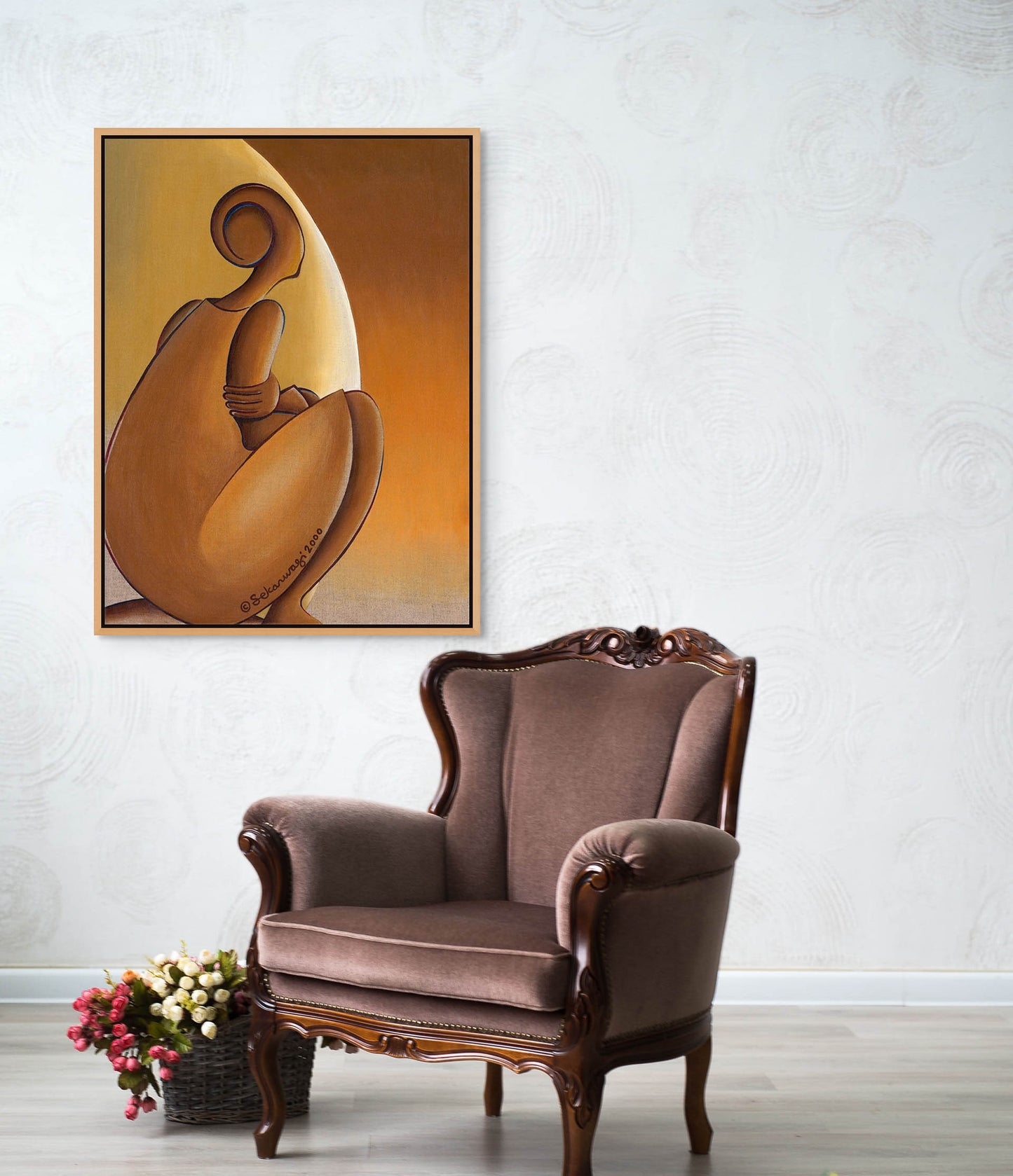 An elegant room has a brown upholstered armchair with carved wooden details. Above it, "Patience", an abstract painting on premium quality cotton canvas of a seated woman figure in warm tones, hangs on the wall. A small bouquet of flowers rests on the floor nearby, creating a tranquil setting.