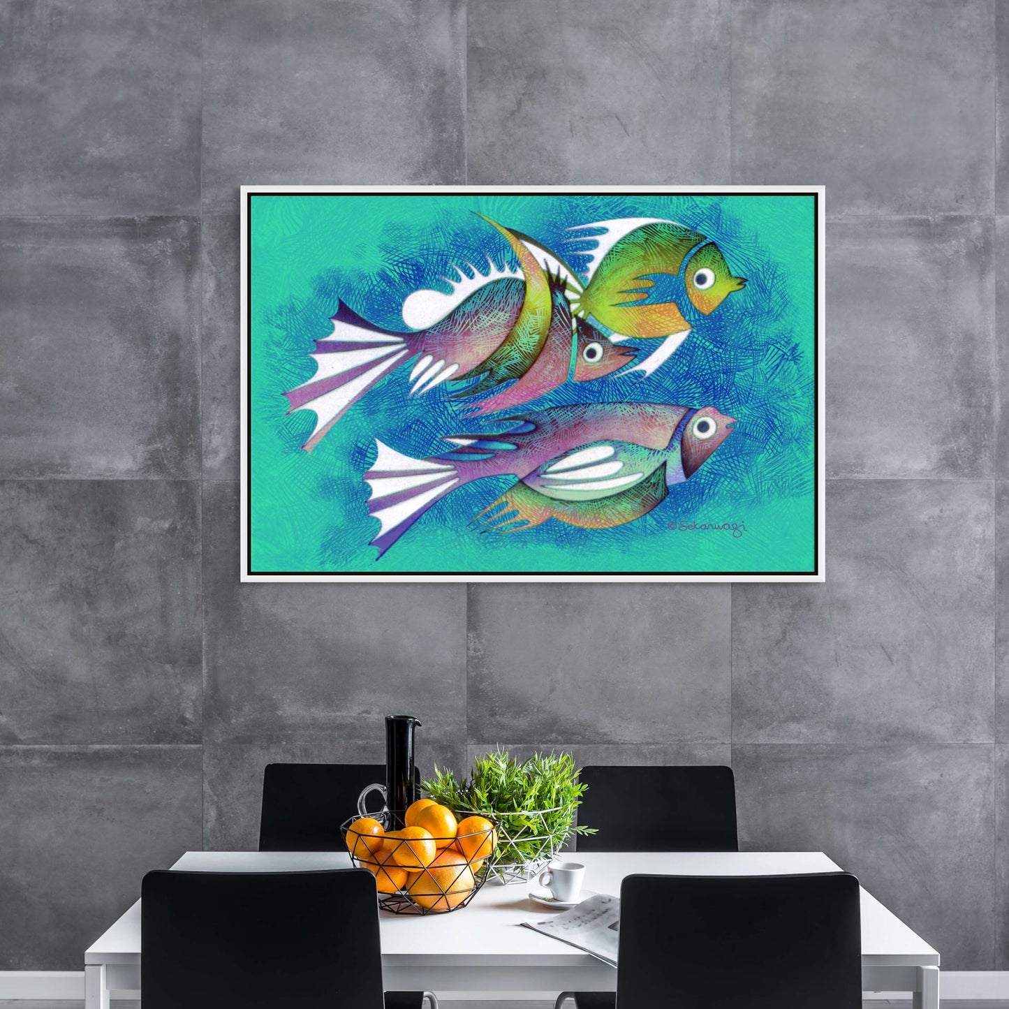 A serene dining area for four is composed of a table with oranges, a small plant, and a black bottle. Above, the "Aquarium #2" Canvas Art with a white floater frame depicting three abstract fish on a turquoise background hangs on a textured gray wall, enhancing the tranquil ambiance.