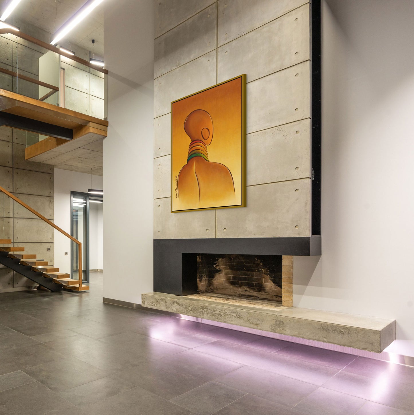 The modern interior with concrete walls and floors showcases the Elegance - Contemporary African Minimalist Canvas Art Print of a person with neck rings above a minimalist fireplace. Ready to hang, it beautifully complements the wooden staircase and glass railing in the background.