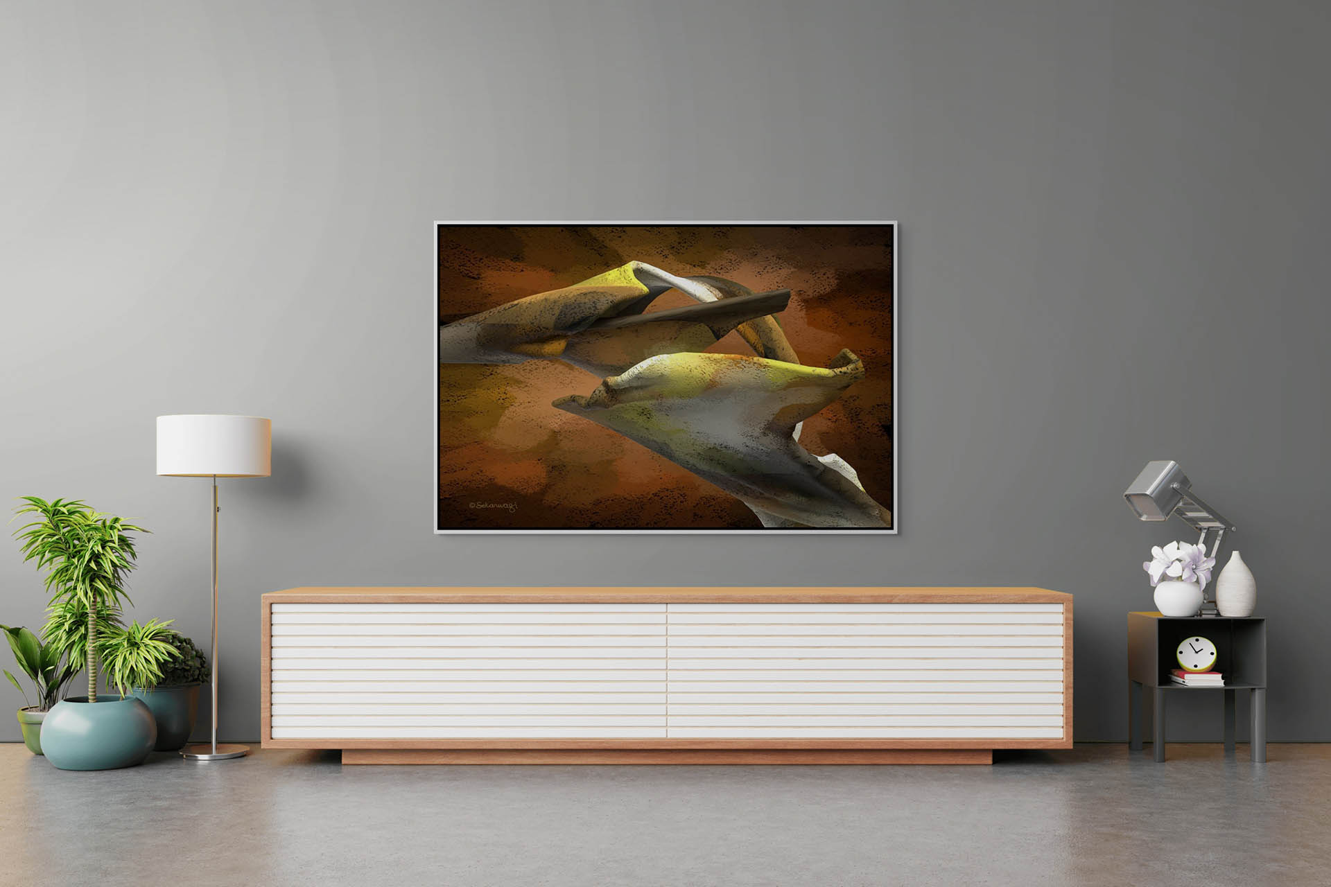 A modern, minimalist living room features a wood and white sideboard with a small plant, lamp, and clock. Above it hangs Floating Thoughts, customized framed artwork in abstract earth tones. The gray wall and floor complement the serene ambiance perfectly.