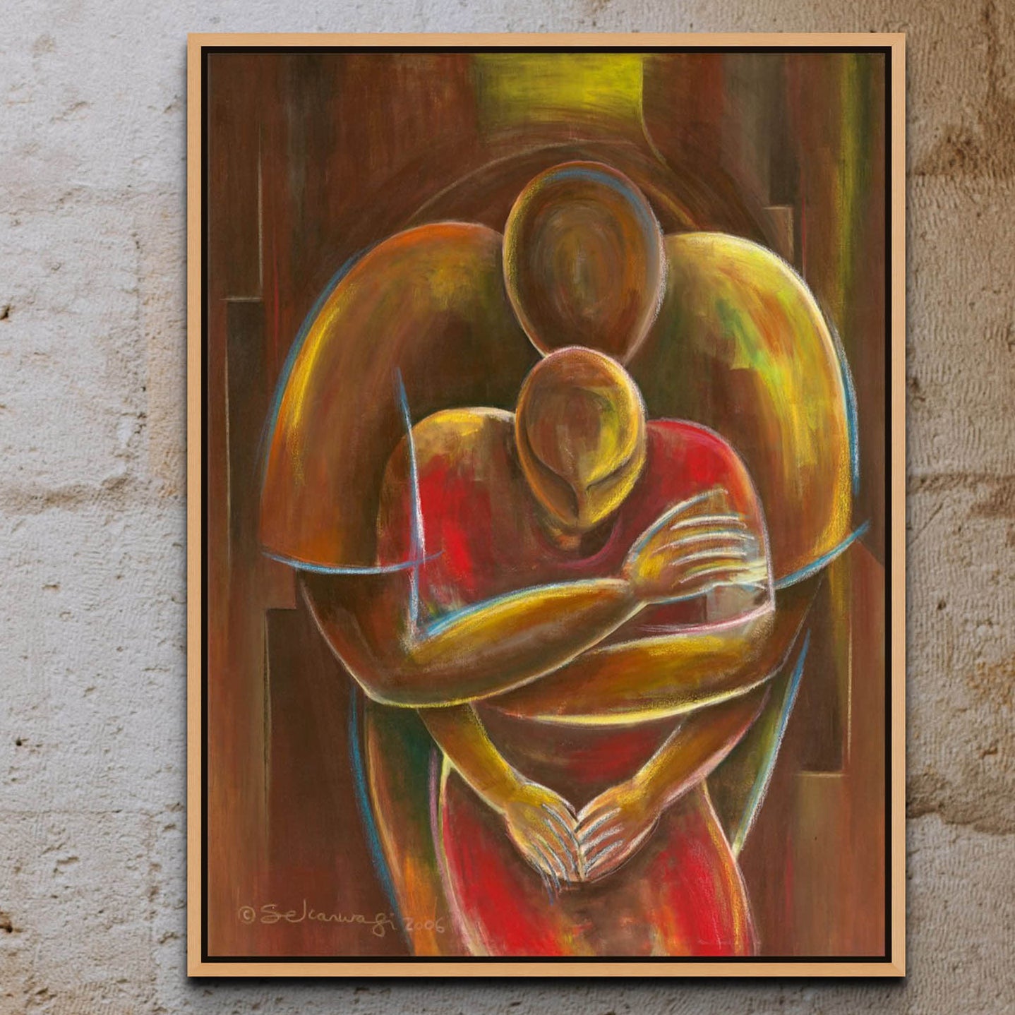 The Nurturing - Canvas Art features two abstract figures with warm colors embracing each other, blending into a unified form. Its ready to hang on a textured concrete wall and comes in a simple natural wood frame.