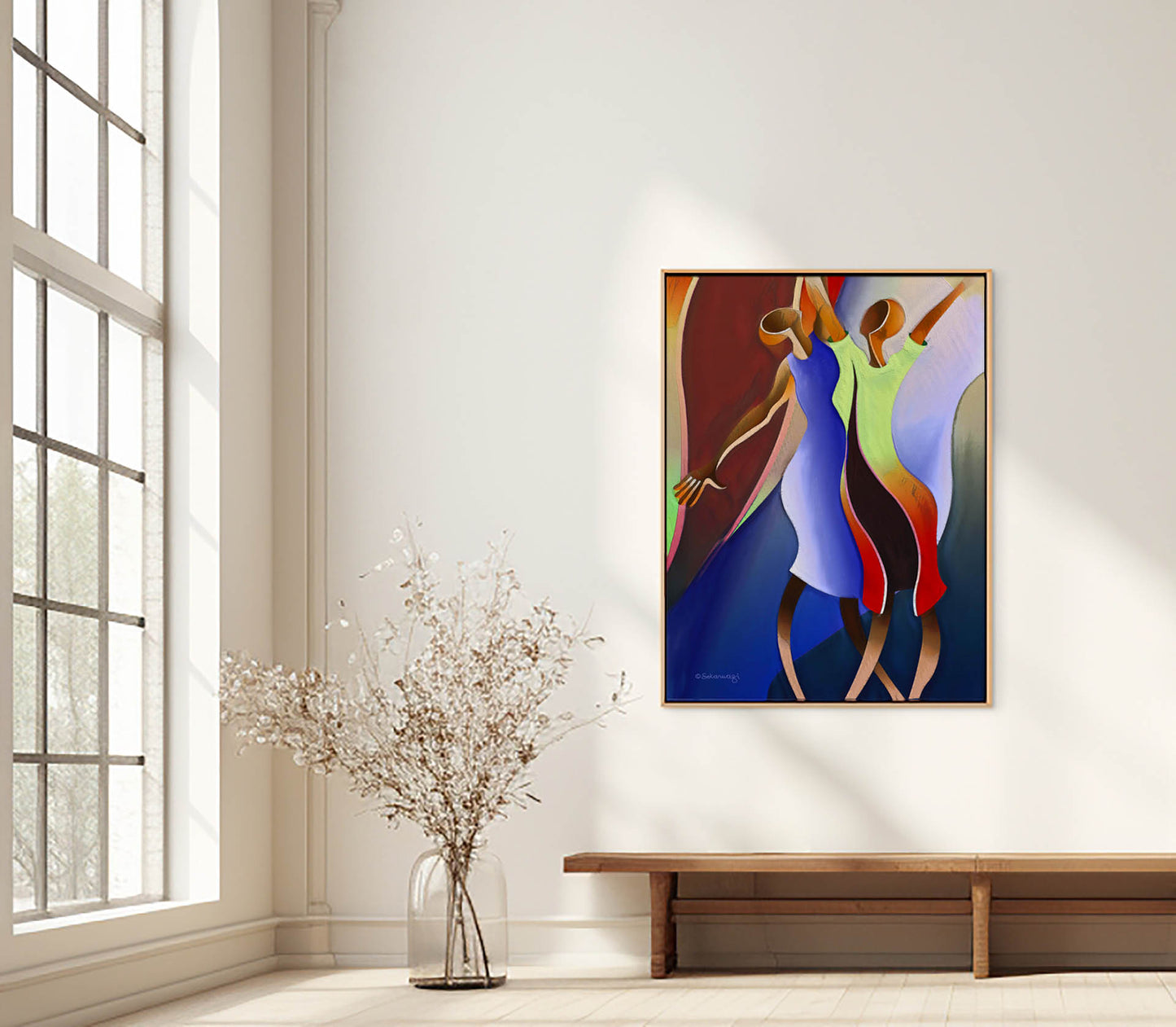 The minimalist room features sunlight streaming through a large window, enhanced by Reaching For The Sky - Canvas Art, a vibrant abstract painting of dancing figures on the wall. A glass vase with dried branches complements the light wooden floor, perfect for art lovers with free shipping included.