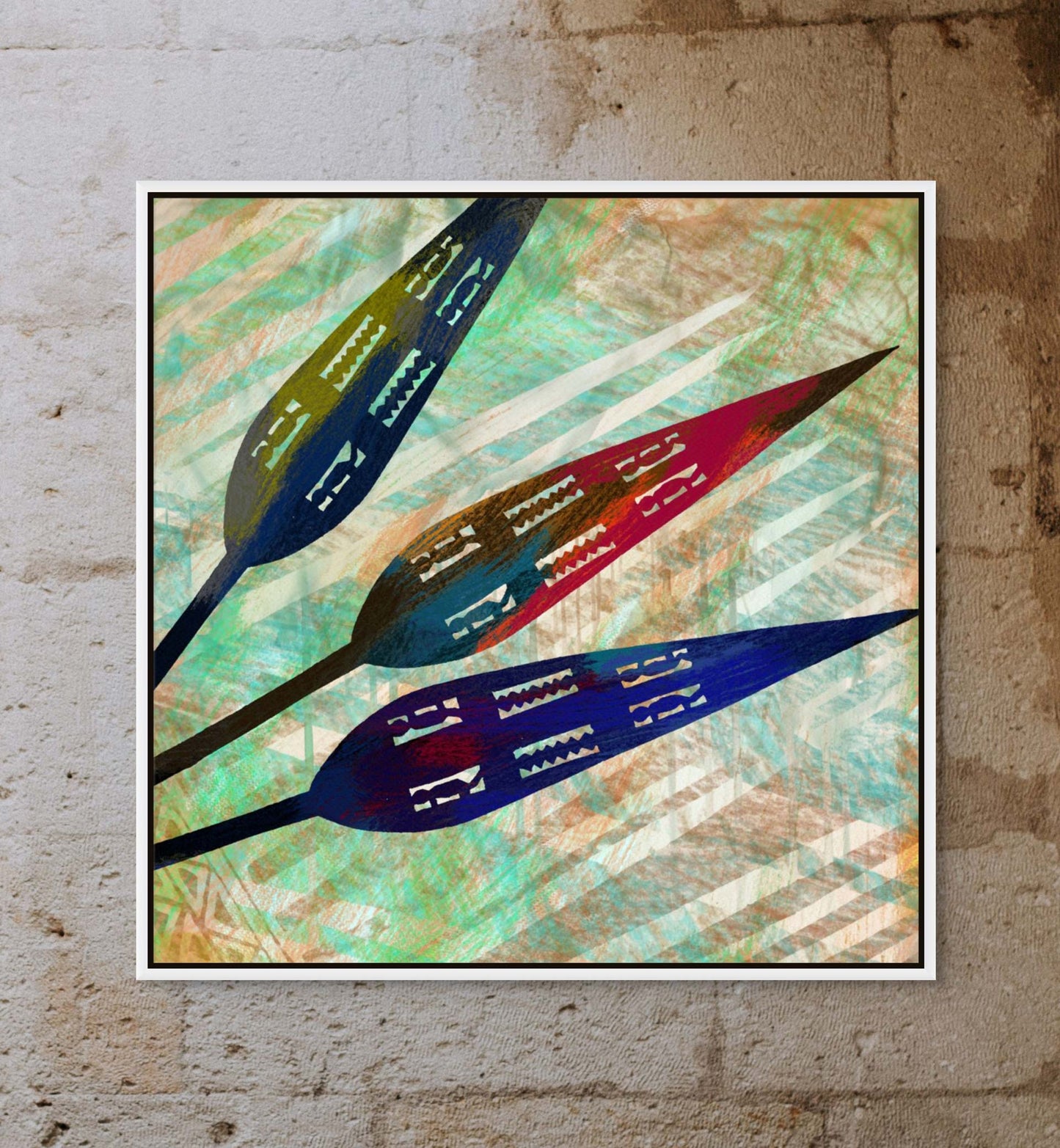 Spearheads- Canvas Art showcases abstract artwork with three stylized leaves in blue, brown, and red against a textured, colorful backdrop on canvas. Framed and ready to hang on a rough gray stone wall.