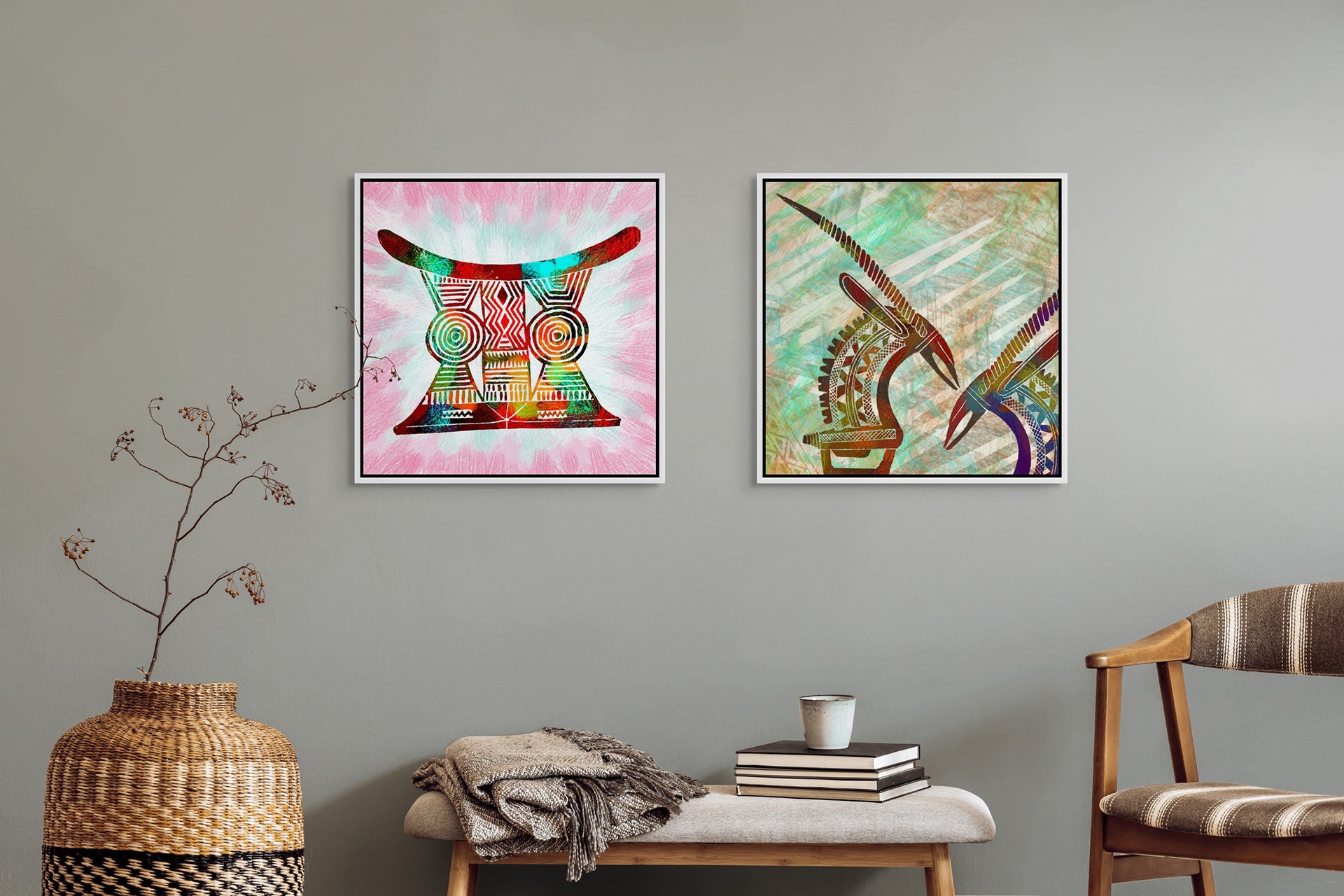 A minimalist room features two abstract art pieces: the left with vibrant, circular patterns inspired by African art and the right with stylized birds. A woven basket with branches, a Canvas Art stool, plus a small table holding books and a cup complete the scene.
