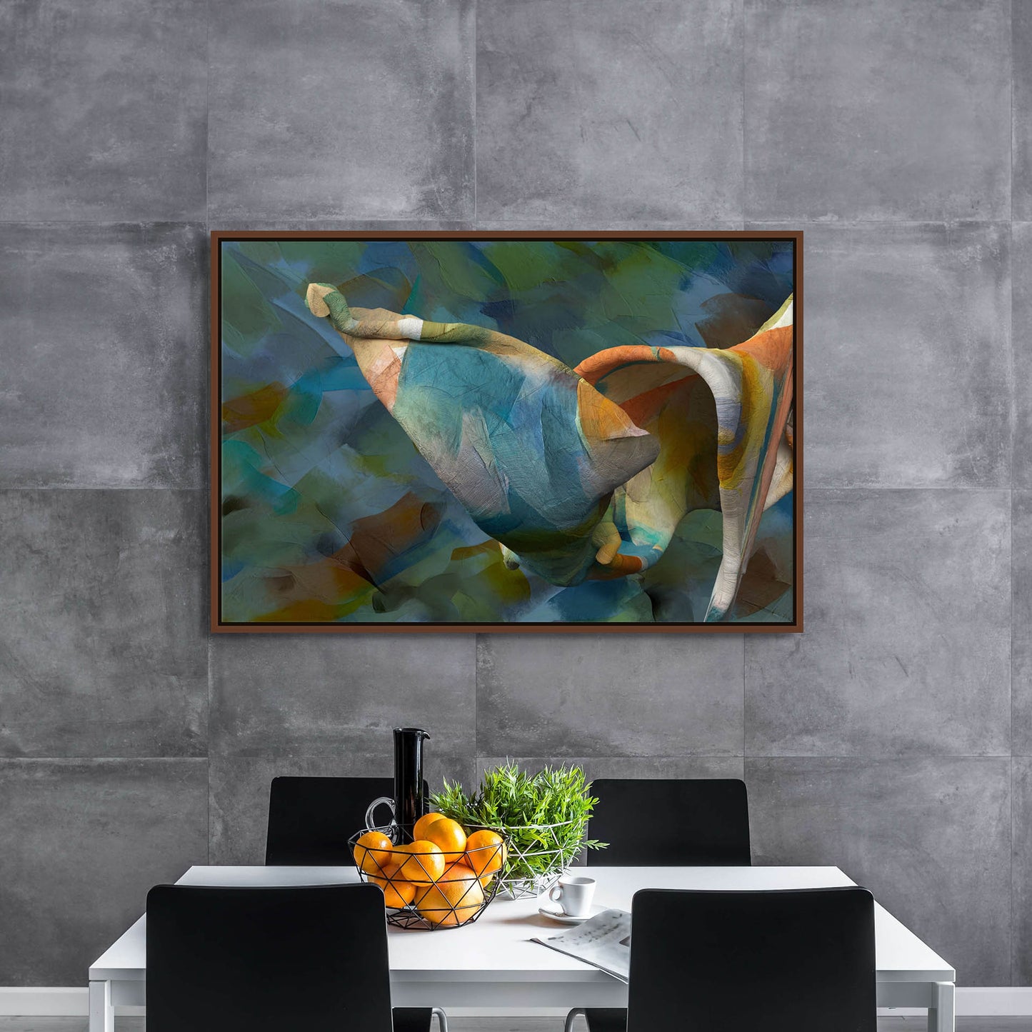 A modern dining area showcases a white table and black chairs, highlighted by a centerpiece of oranges and greenery. The gray textured wall is elegantly adorned with Unfolding Thought canvas art, featuring colorful abstract patterns reminiscent of giclee prints.