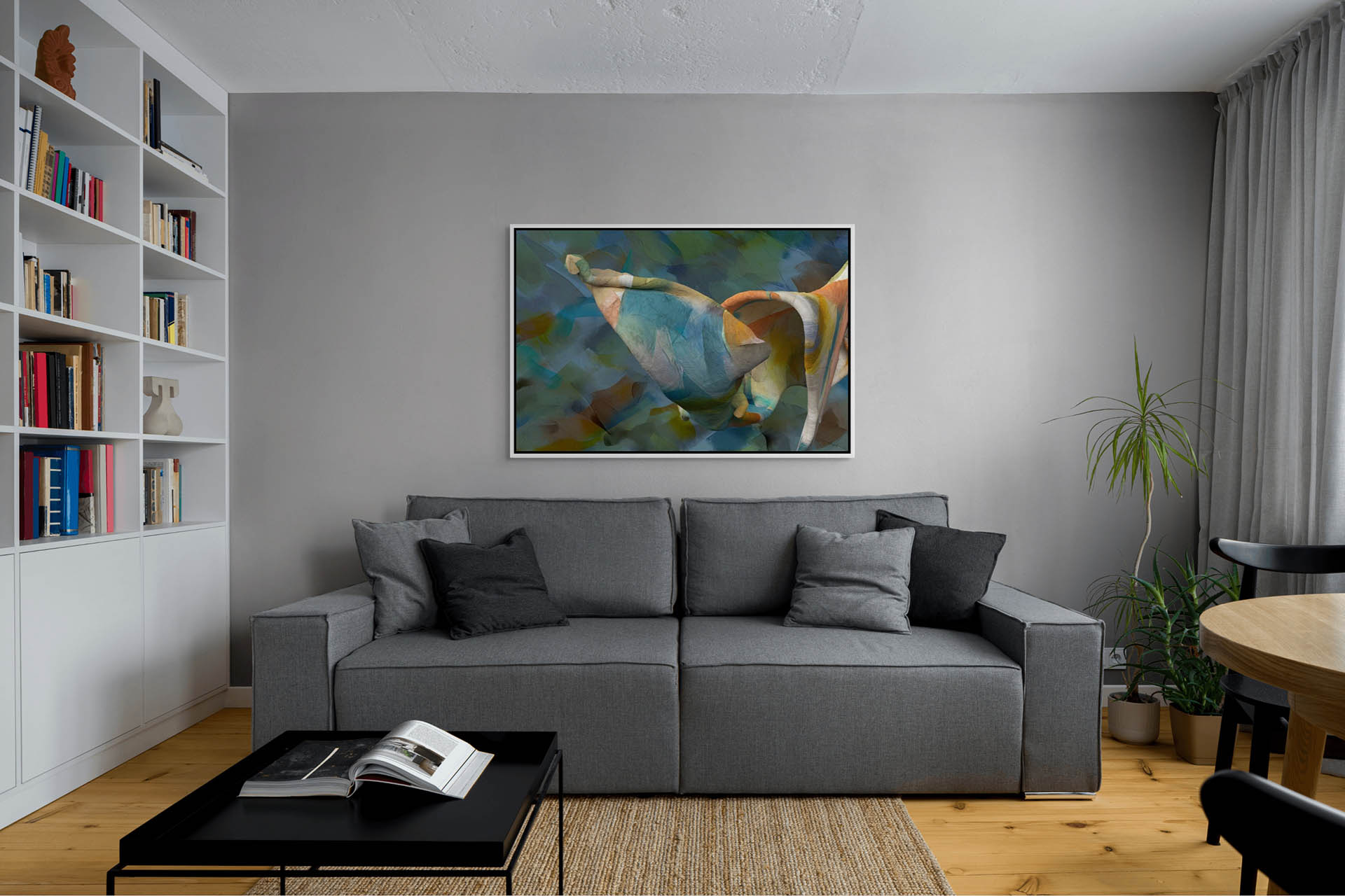 A modern living room features a grey sofa and black coffee table alongside bookshelves. Unfolding Thought - Canvas Art adds color above the sofa on a grey wall. A small plant sits near the window with grey curtains.