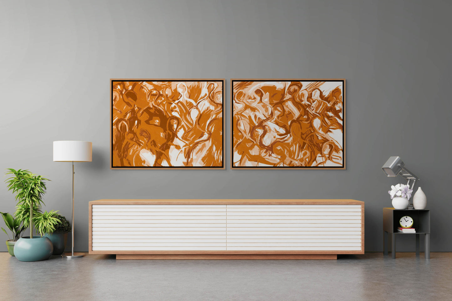 In a modern living room, two We Are All Connected abstract orange canvases embellish a gray wall. Below, a sleek console table in white and wood holds a clock, lamp, and books. A potted plant and floor lamp flank the space, creating an inviting ambiance.