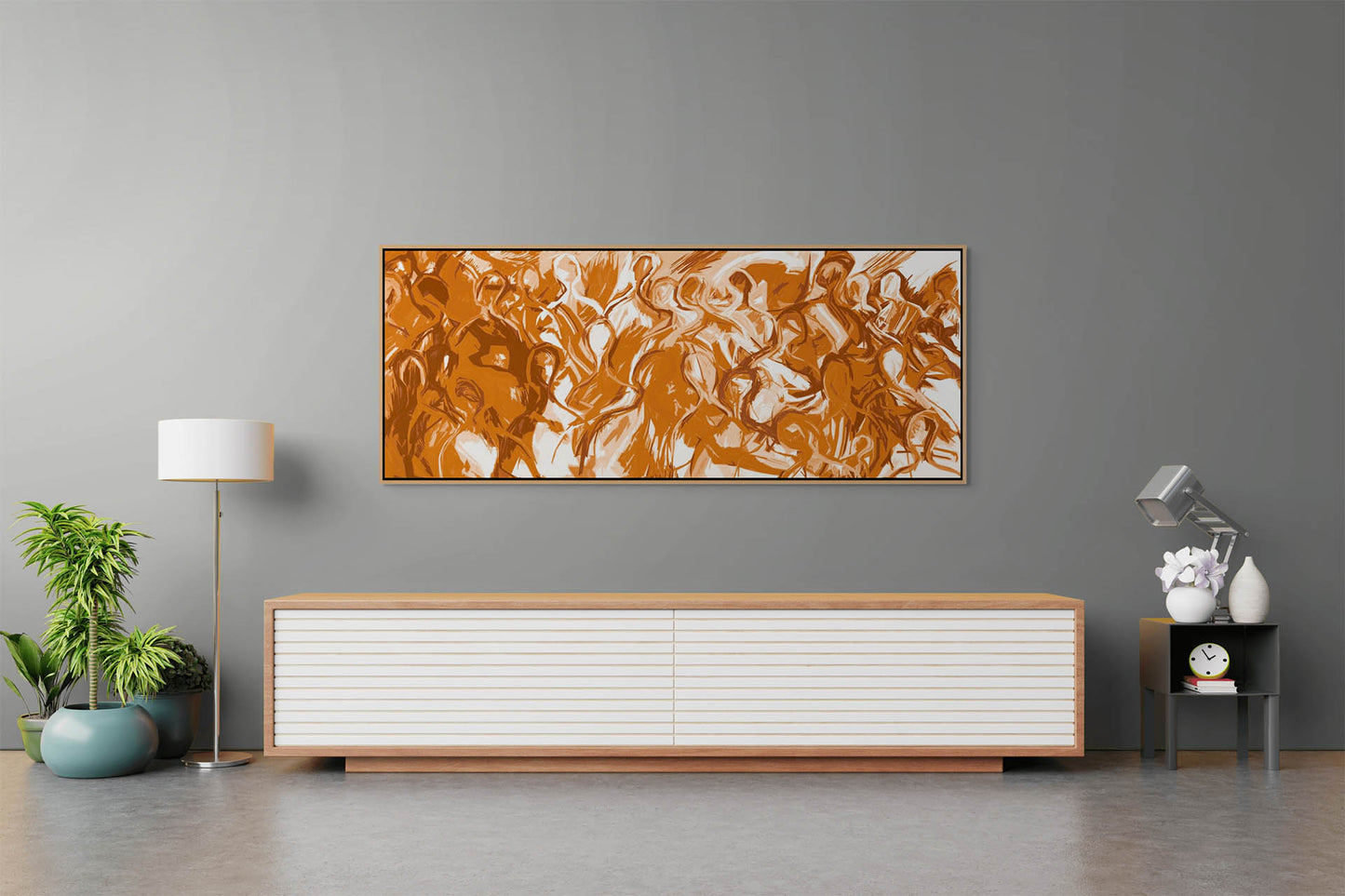 A modern living room features We Are All Connected canvas art with brown and white swirls on a gray wall. Below, a low wooden sideboard with white drawers is accompanied by a potted plant and floor lamp, holding a small clock and book.