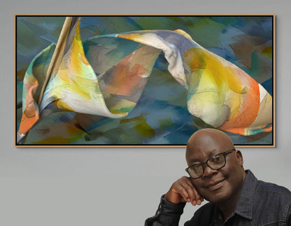 A person in glasses and a dark jacket leans on a counter, smiling. Behind them is Shape Of Unfolding Thought—a colorful, abstract canvas art piece with swirling blue, yellow, and orange shapes. Framed and mounted on a gray wall, it includes free shipping as part of our collection.